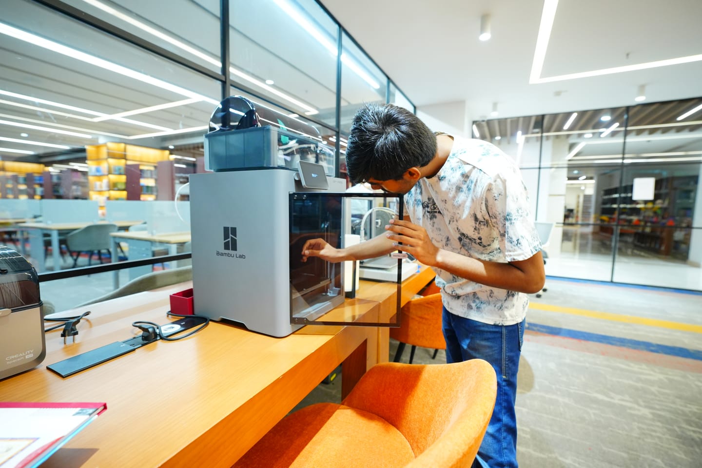 Maker working inside Bambu Lab 3D printer chamber at Galgotias Buildspace